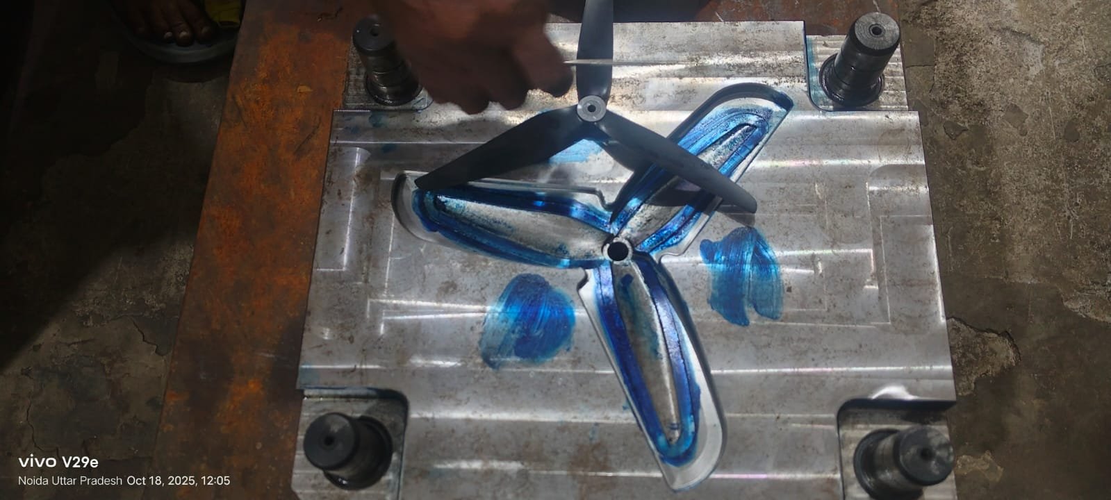 Operator placing finished propeller in mold for inspection